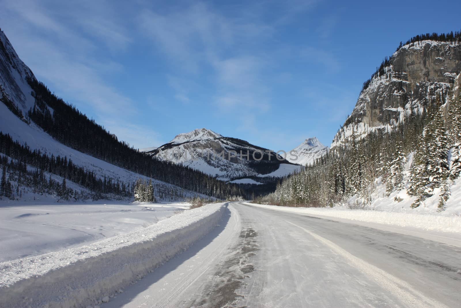 Ice road leading to a mountain under blue sky