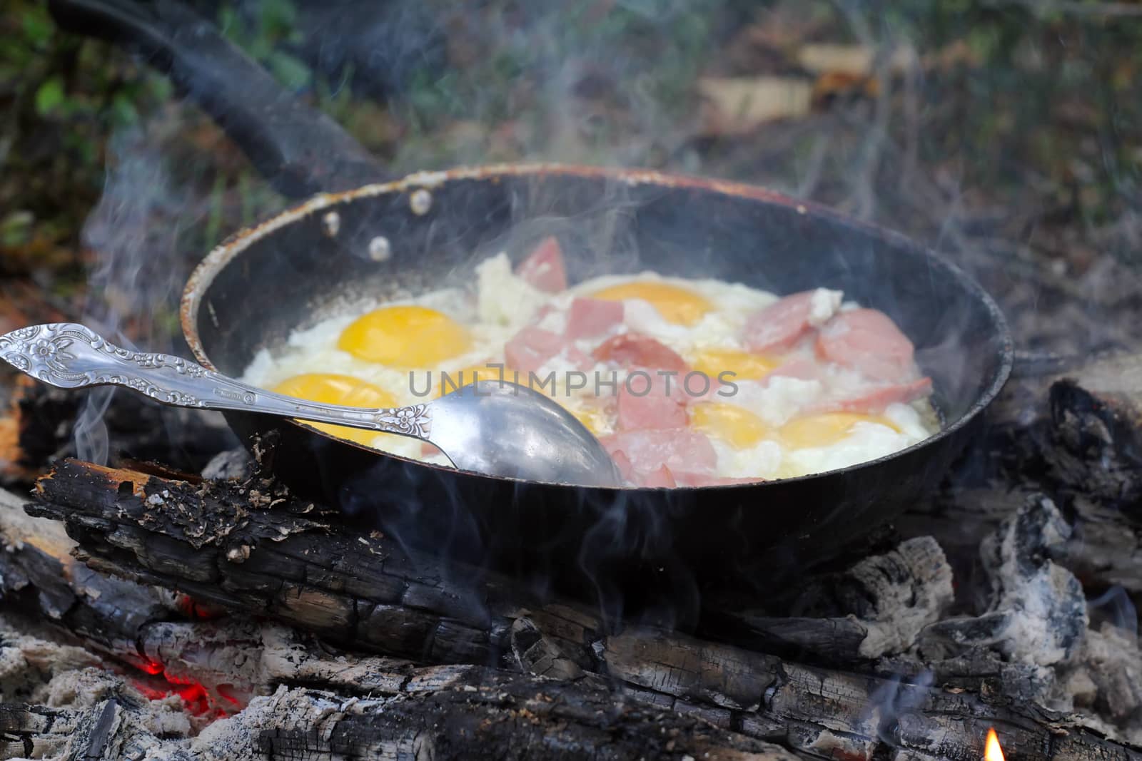 Removed  process of a eggs with sausages on  coals. Shooting closeups