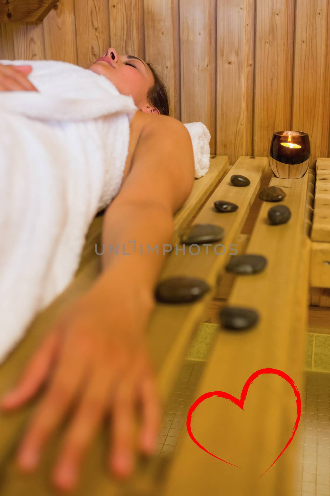 Calm brunette woman lying in a sauna against heart