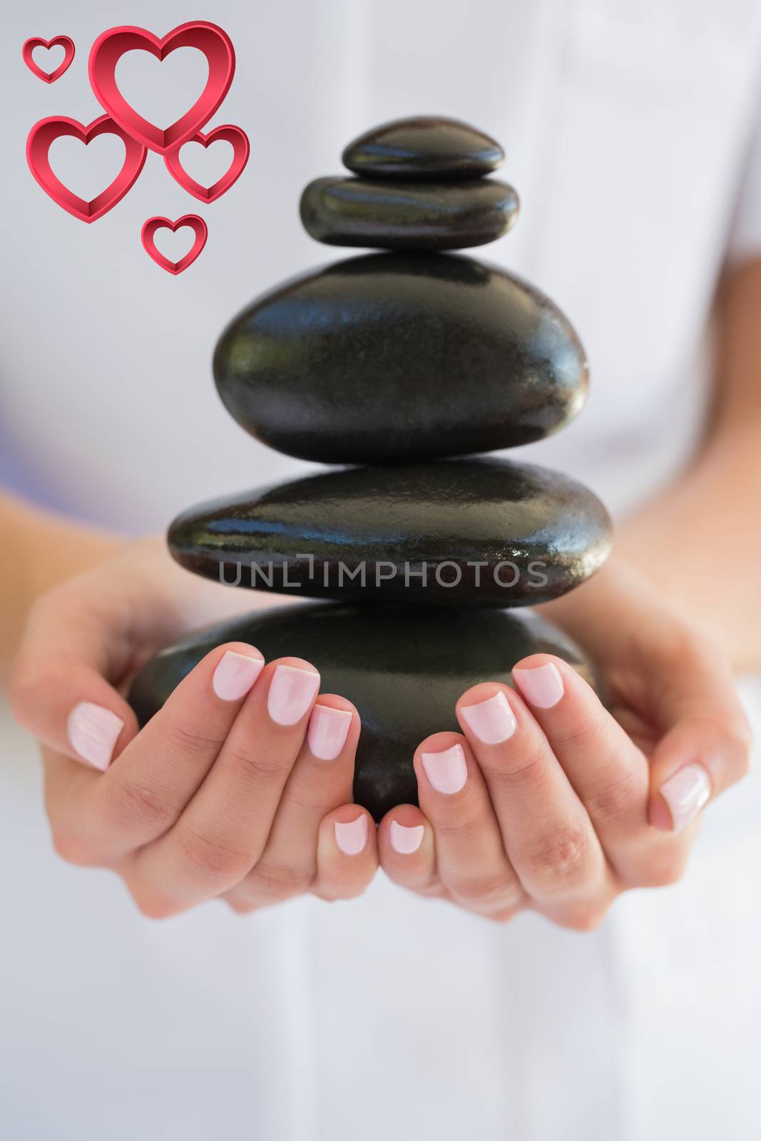 Composite image of beauty therapist holding pile of stones for massage by Wavebreakmedia