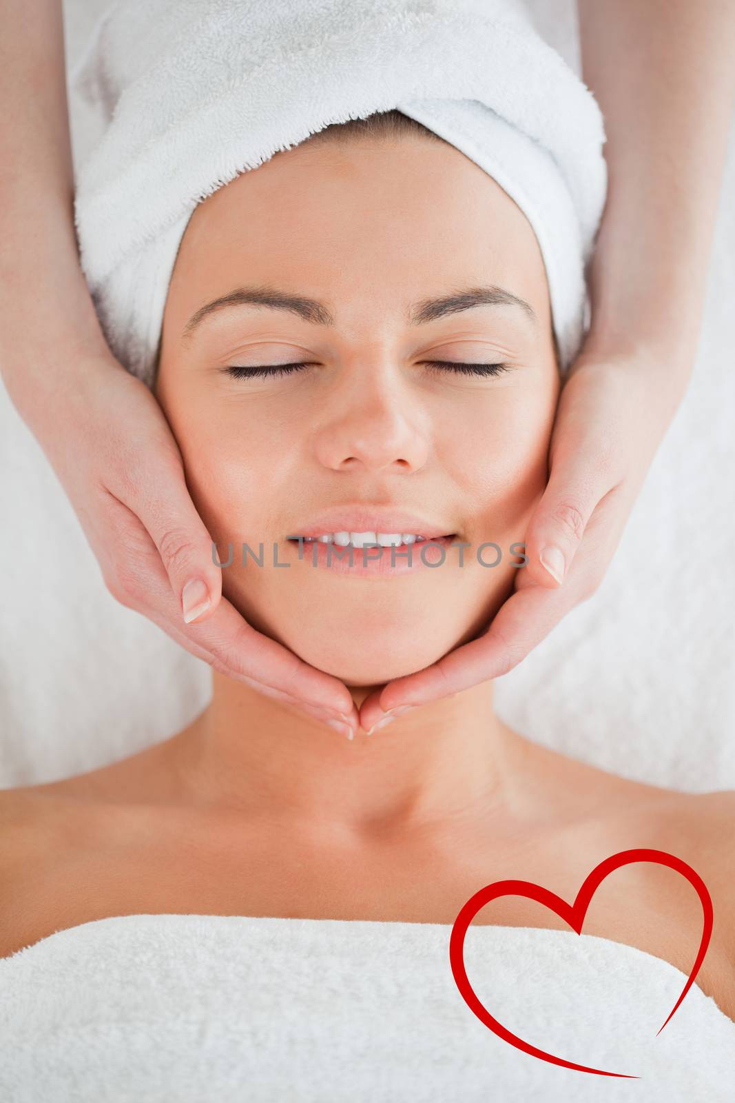 Portrait of a smiling woman having a facial massage against heart