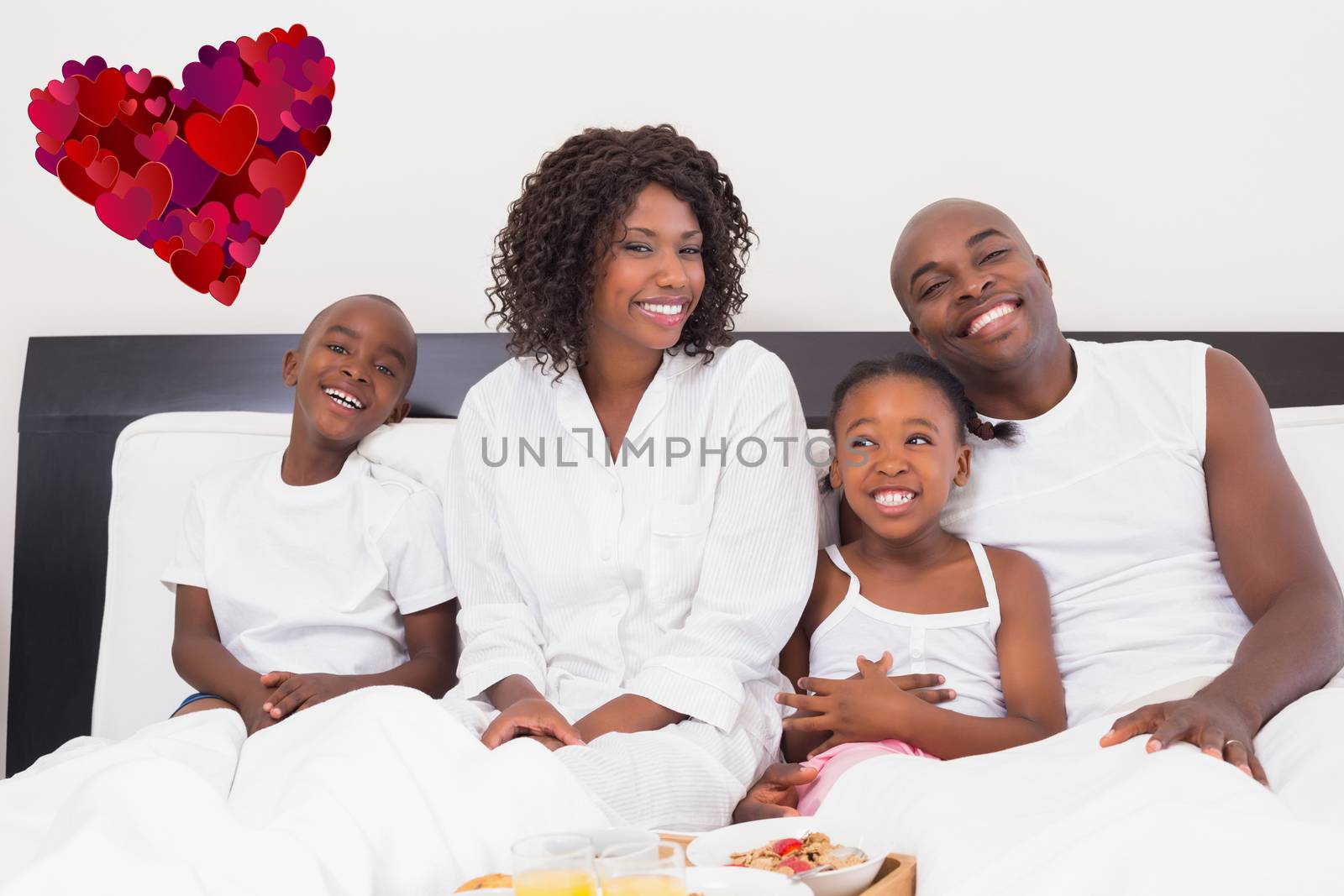 Composite image of happy family having breakfast in bed by Wavebreakmedia