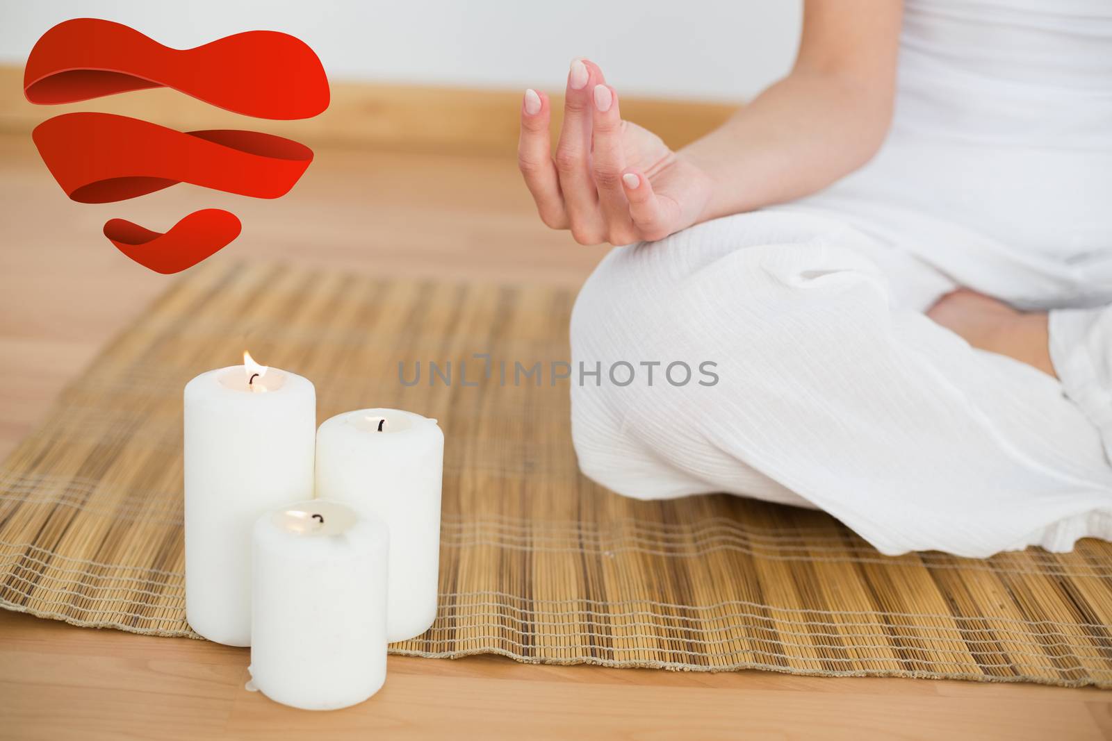 Woman sitting in lotus pose beside white candles against heart