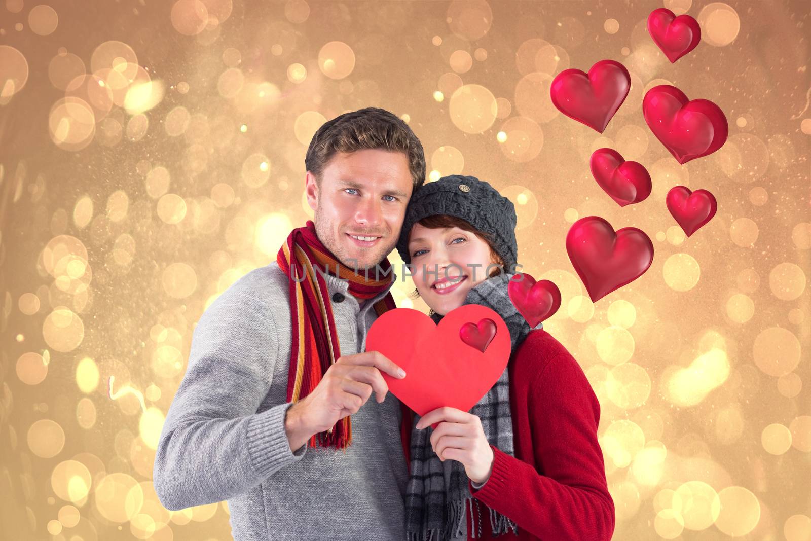Couple holding a red heart against yellow abstract light spot design