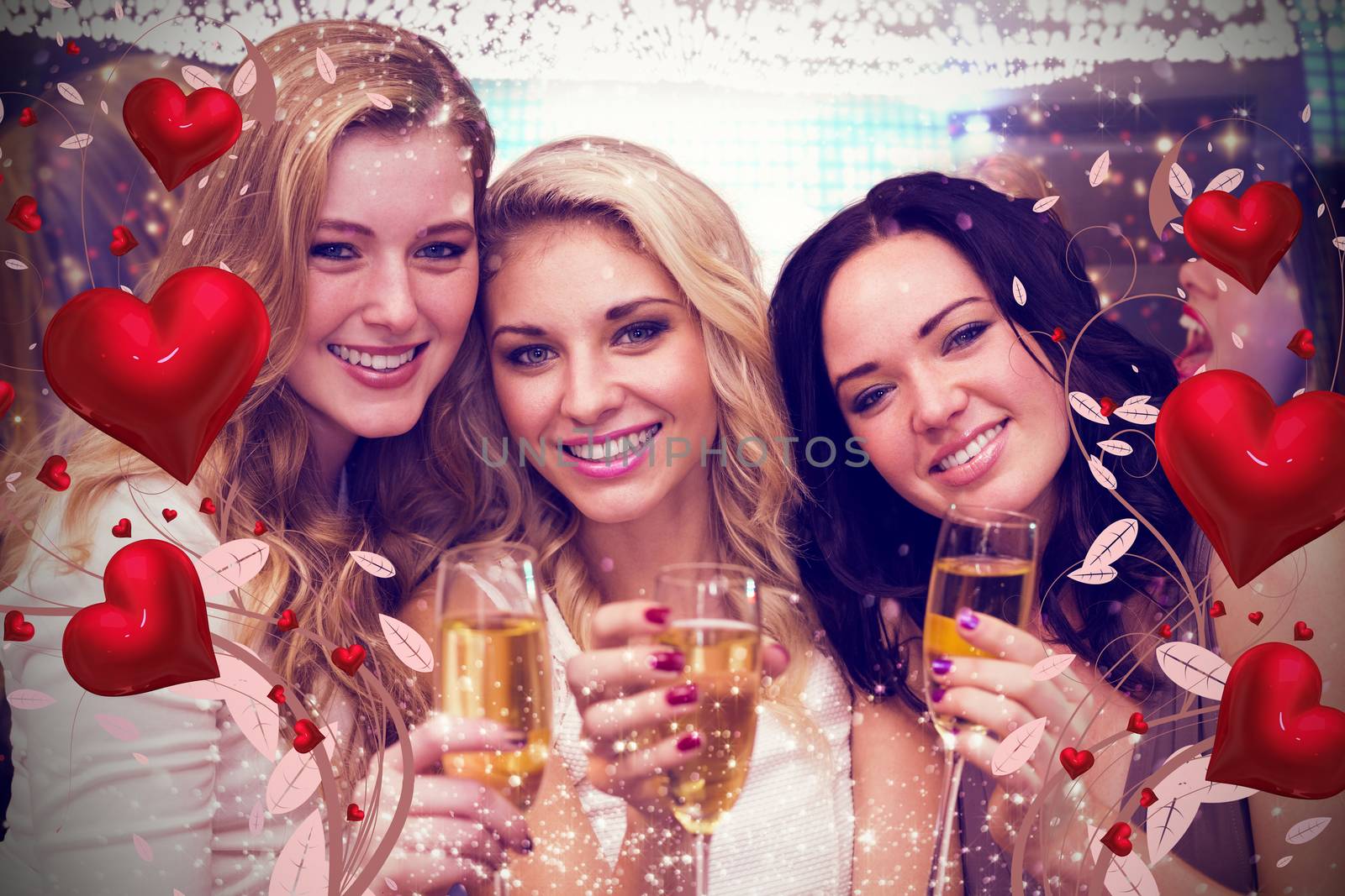 Pretty friends drinking champagne together against valentines heart design
