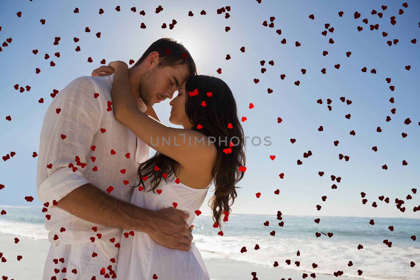 Romantic couple embracing  against red love hearts