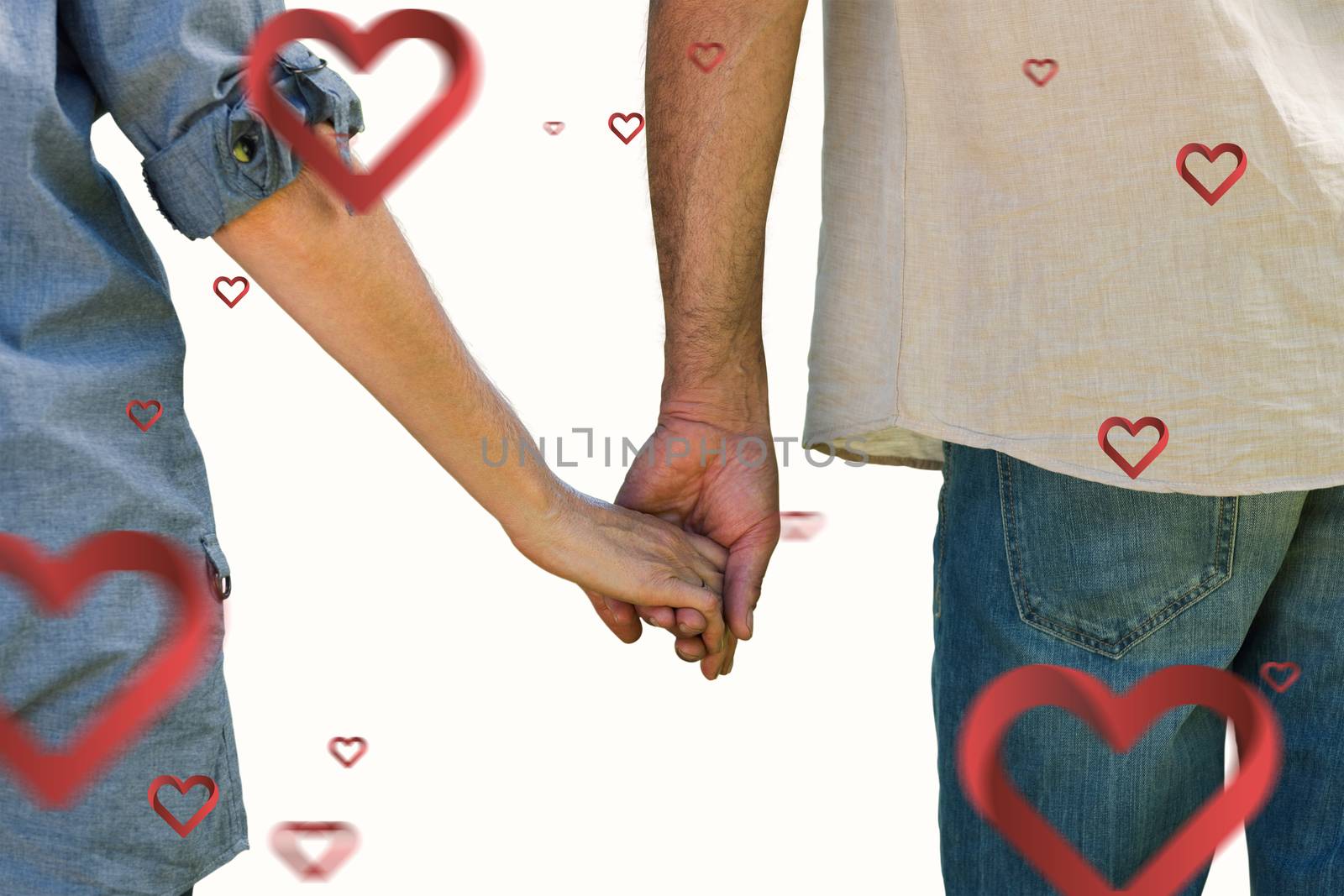 Couple holding hands in park against hearts