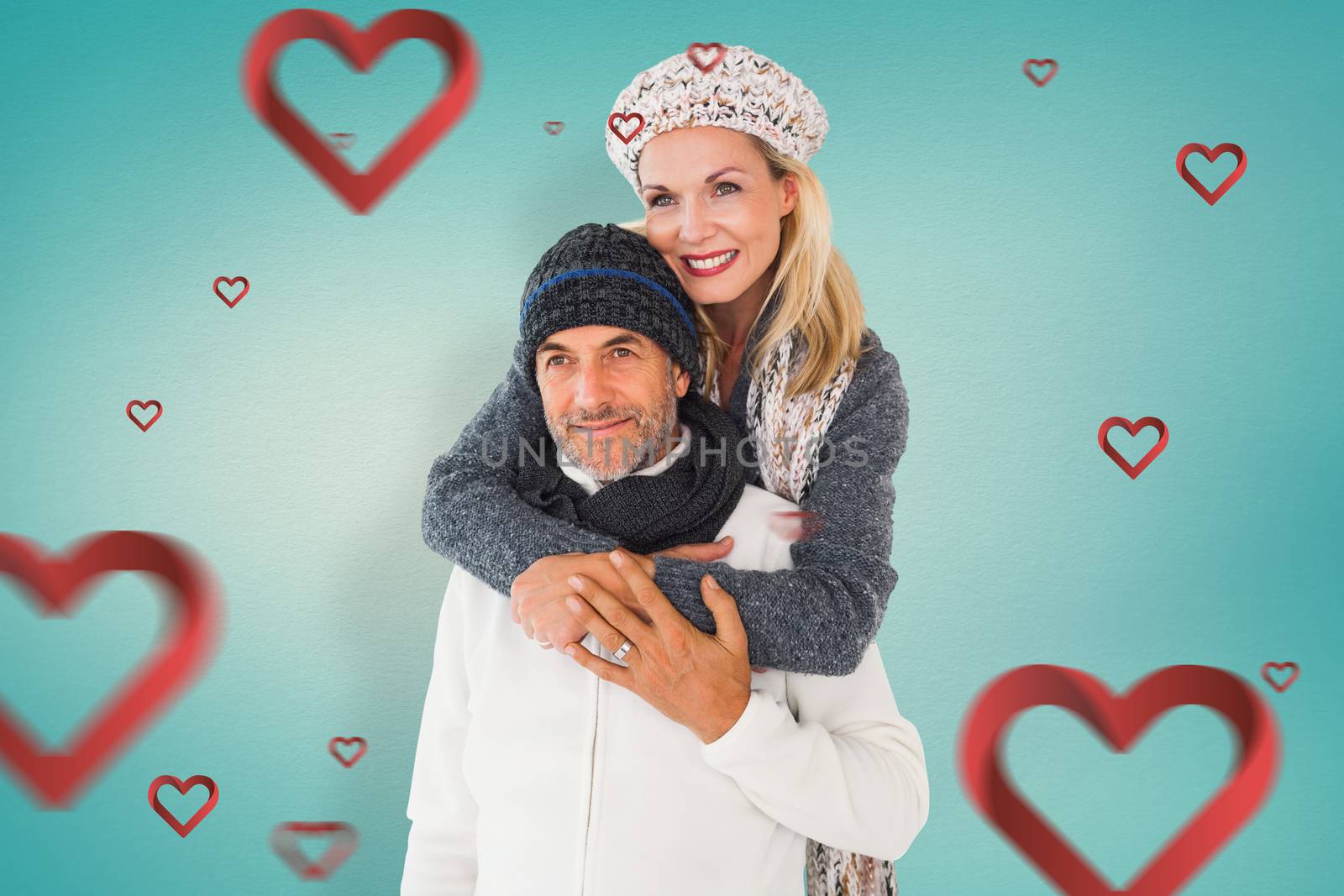 Happy couple in winter fashion embracing against blue vignette background