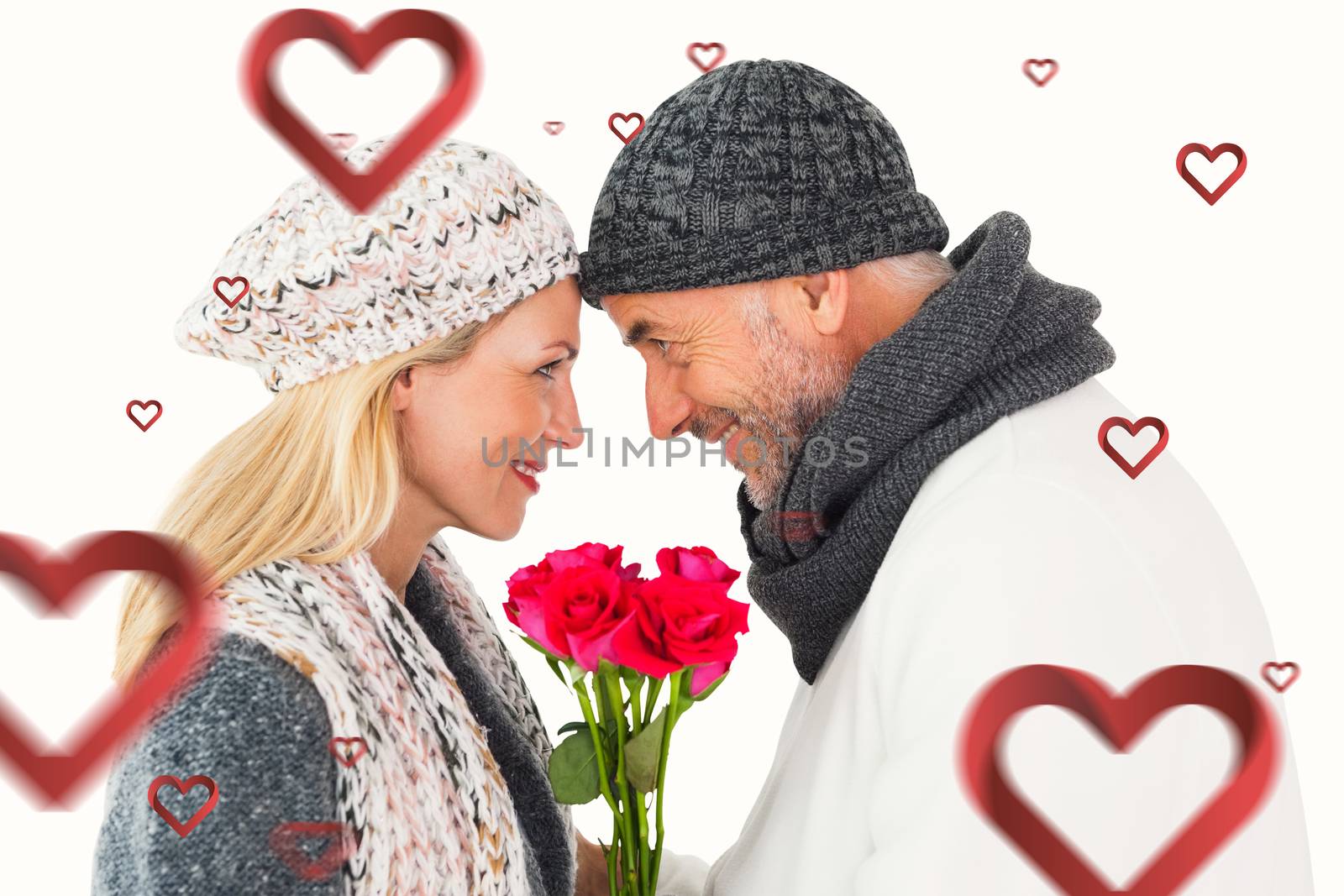 Smiling couple in winter fashion posing with roses against hearts