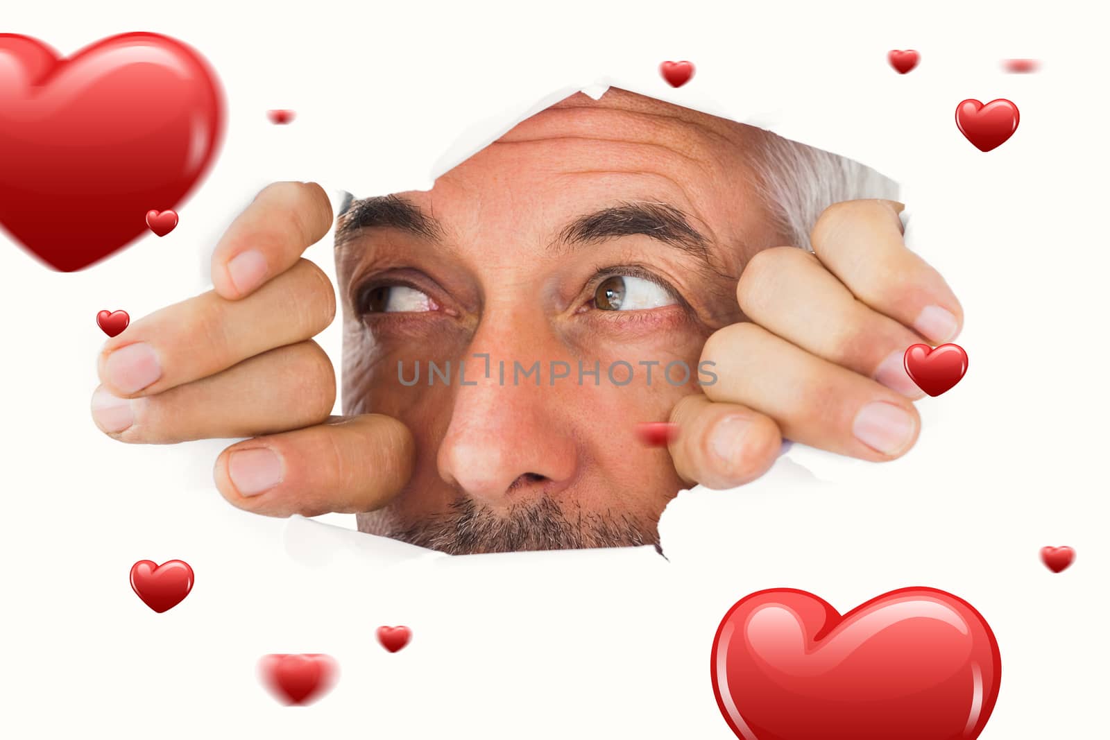 Man looking through torn paper against hearts
