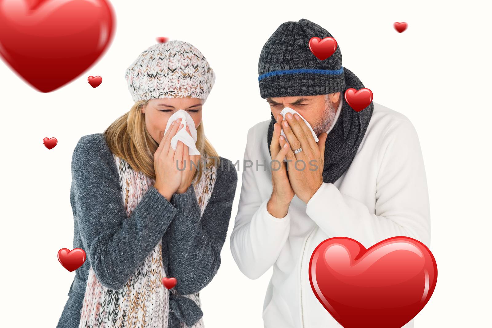Sick couple in winter fashion sneezing against hearts