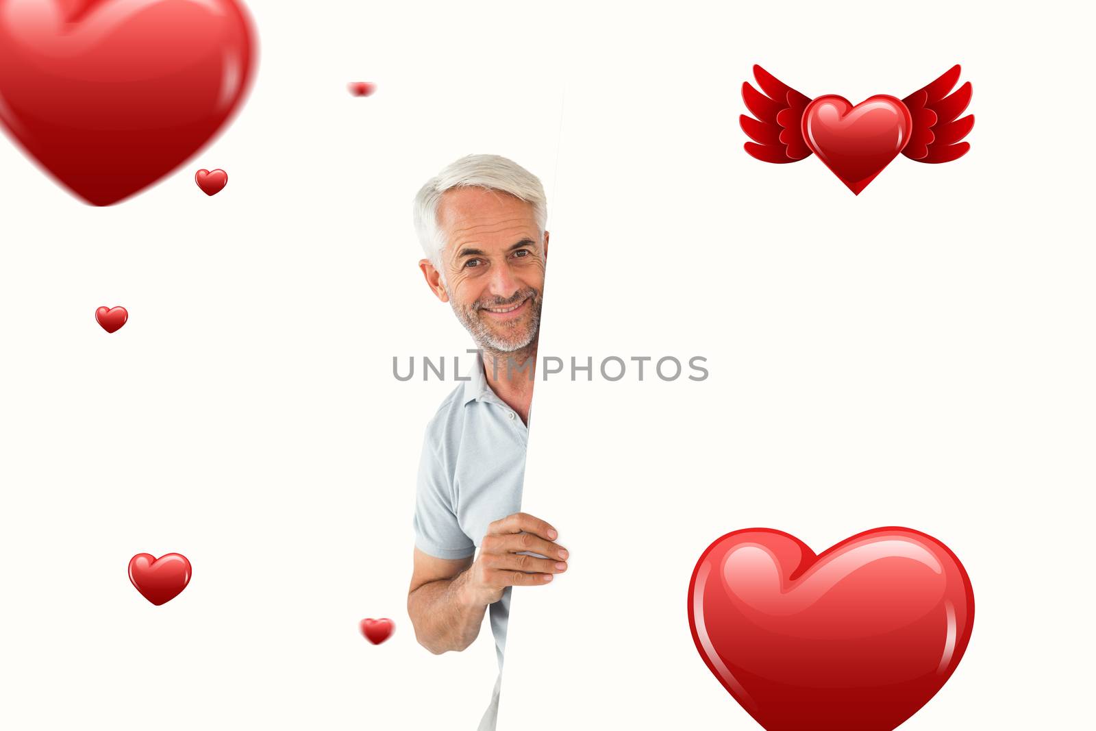 Smiling man showing large poster against hearts