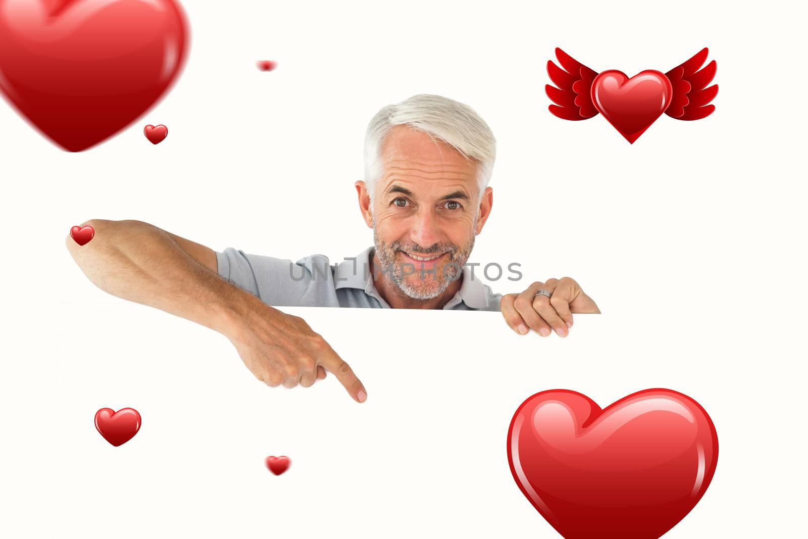Smiling man showing large poster against hearts