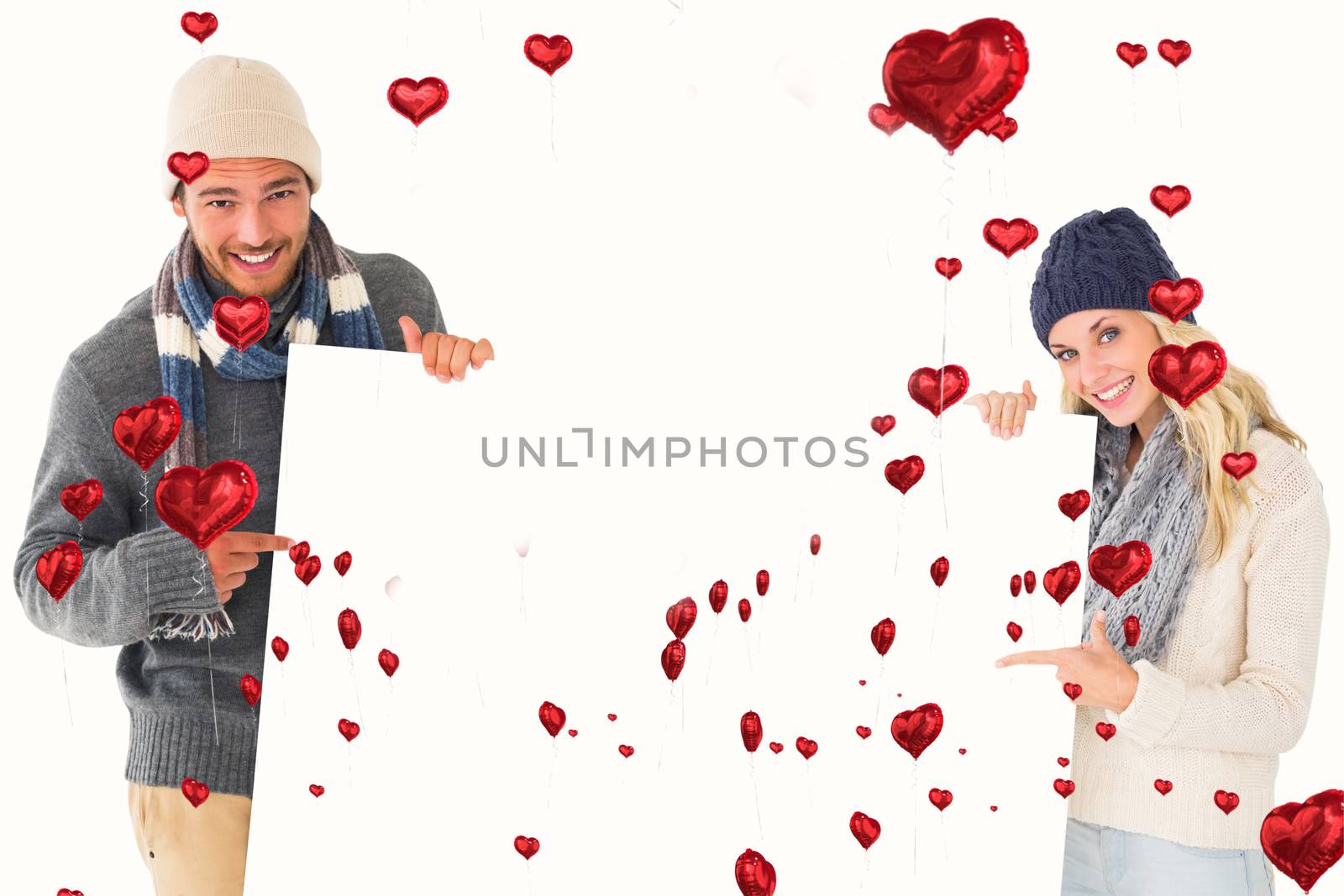 Composite image of attractive couple in winter fashion showing poster by Wavebreakmedia