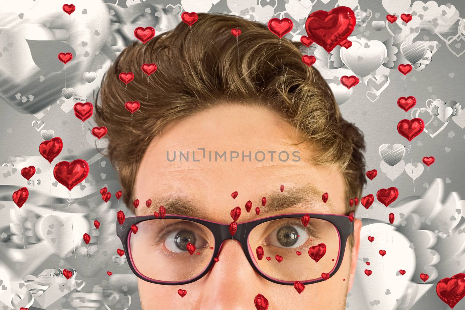 Geeky businessman looking at camera against grey valentines heart pattern