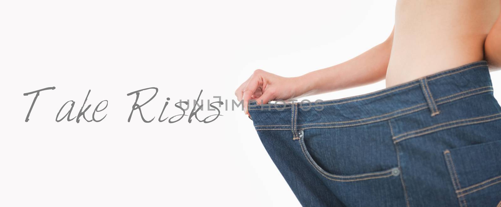 Close up of a woman belly in too big pants against white background