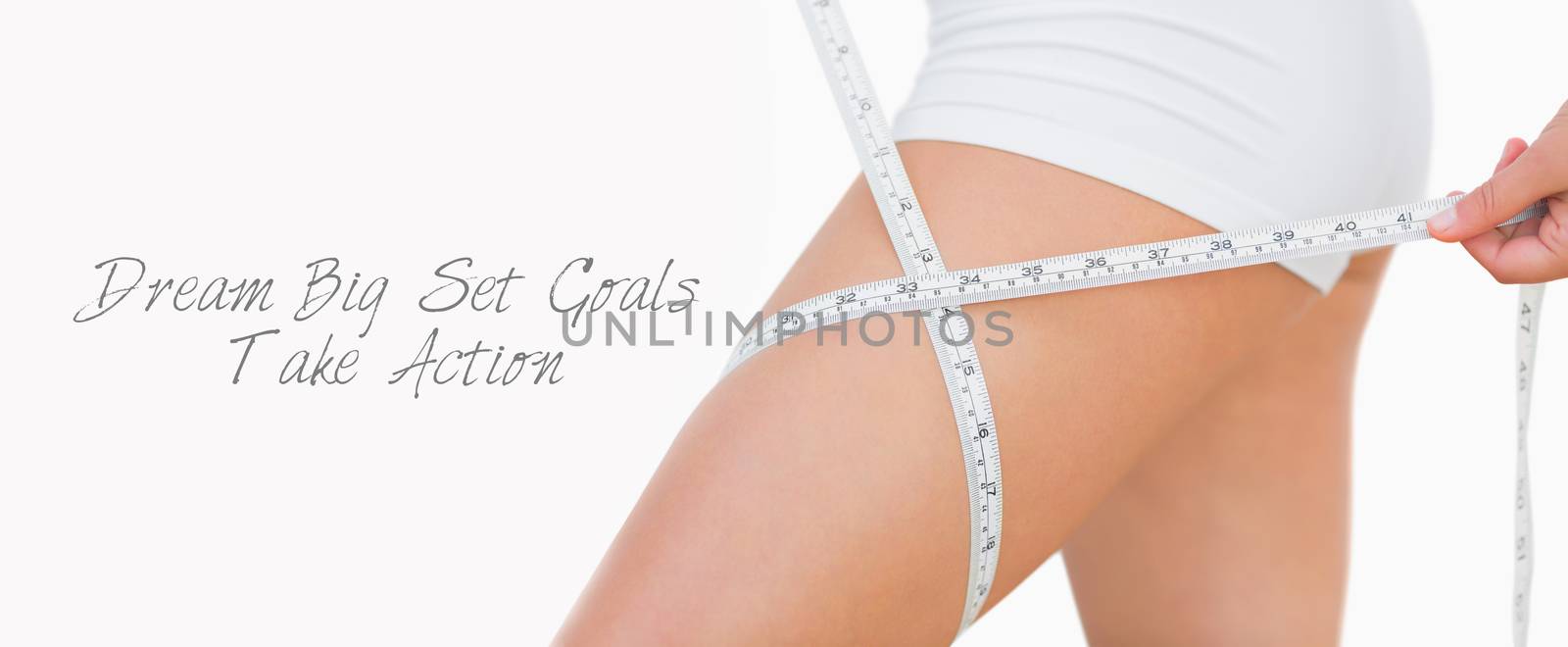 Midsection of woman measuring thigh  by Wavebreakmedia