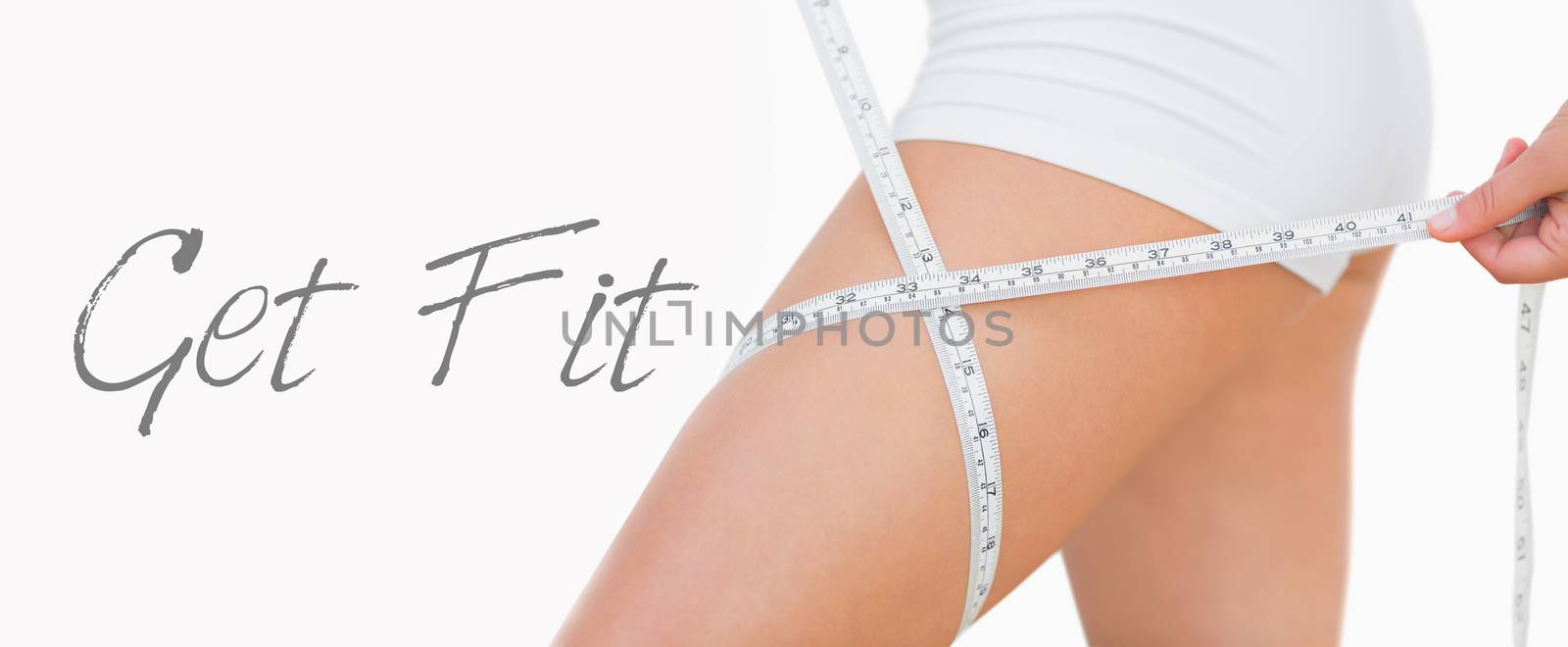 Midsection of woman measuring thigh  by Wavebreakmedia