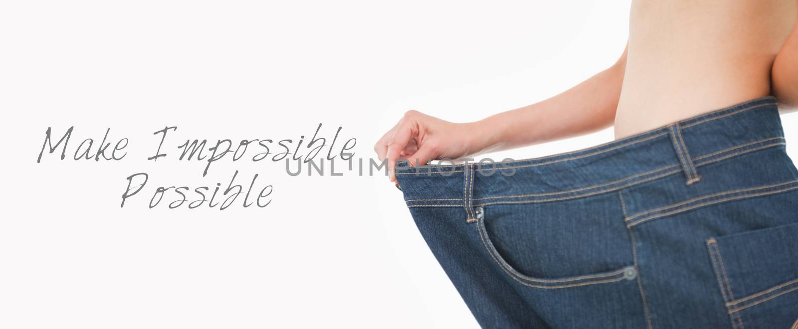 Close up of a woman belly in too big pants against white background