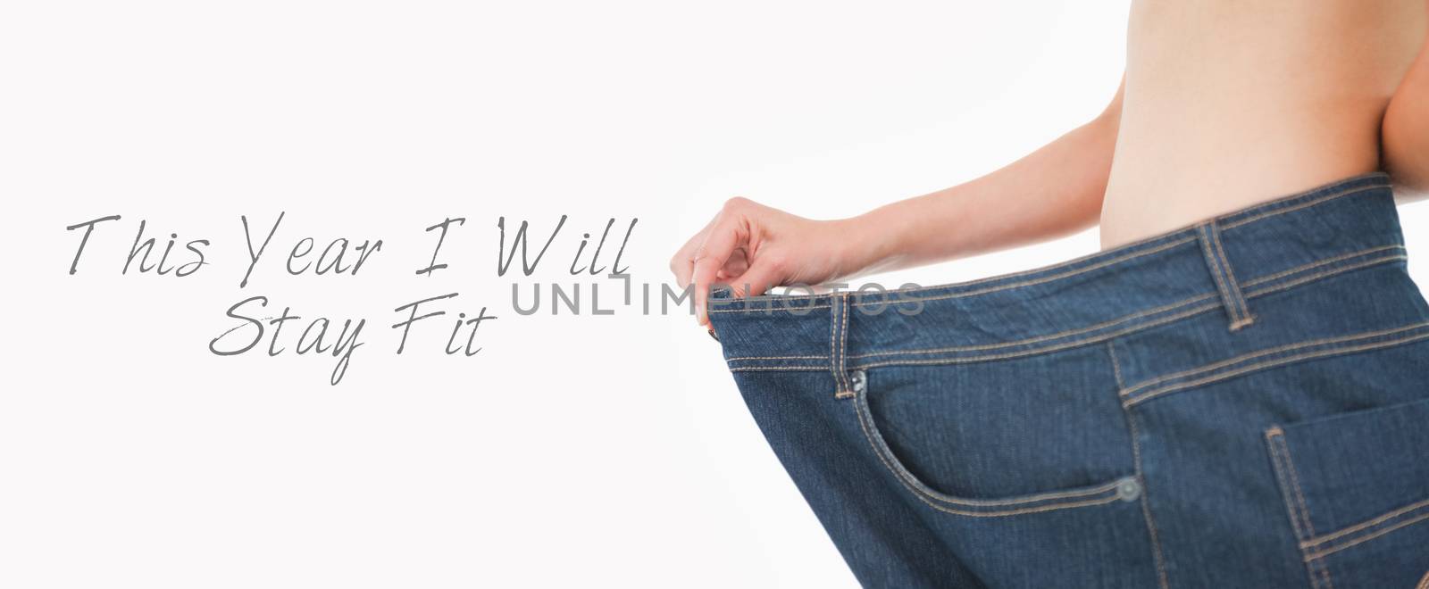 Close up of a woman belly in too big pants against white background