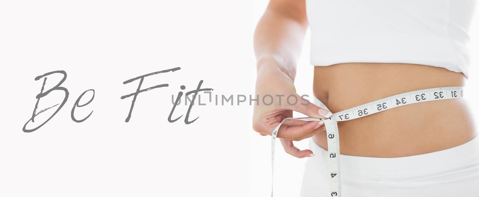 Closeup midsection of woman measuring waist over white background