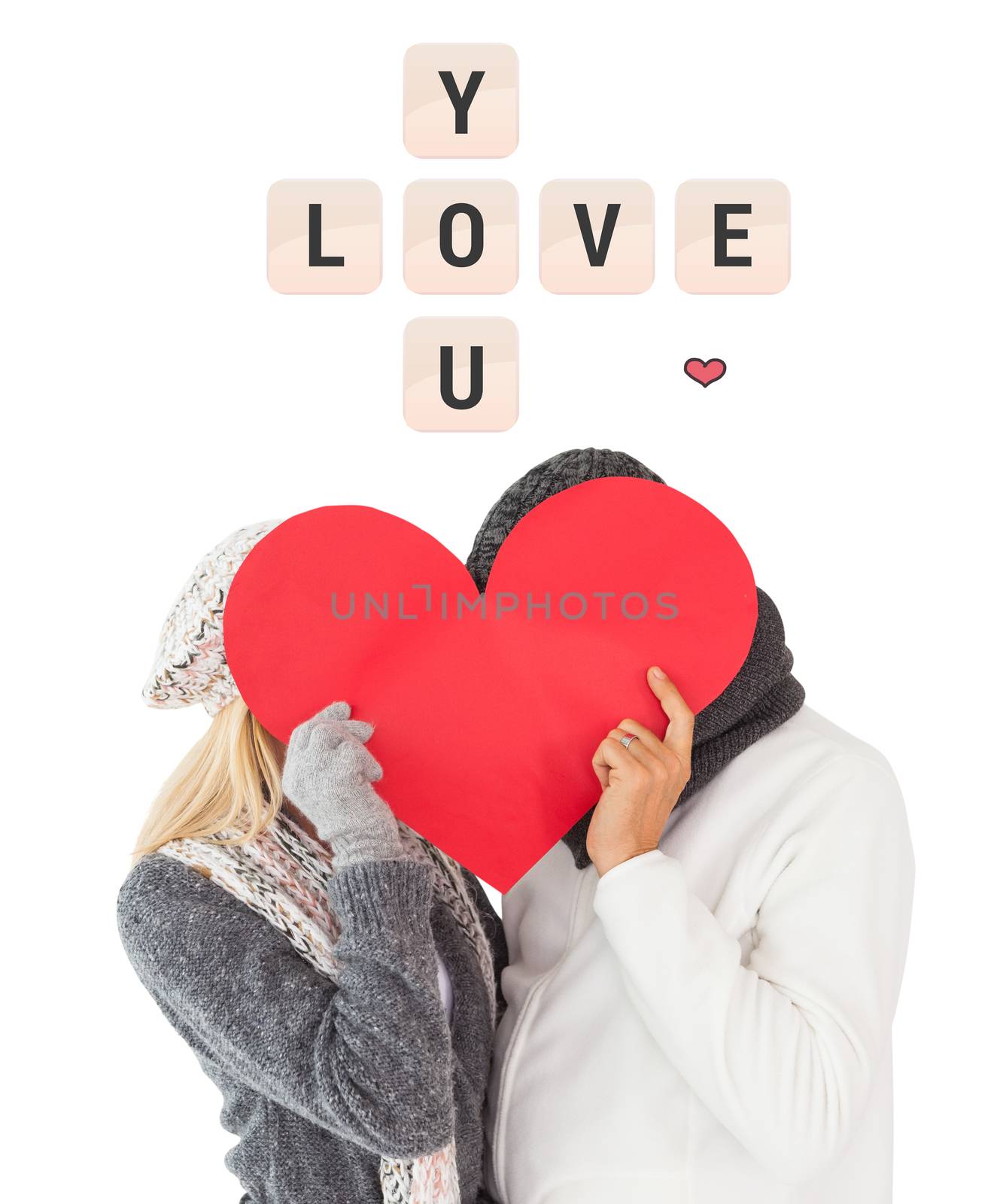 Couple in winter fashion posing with heart shape against love you tiles