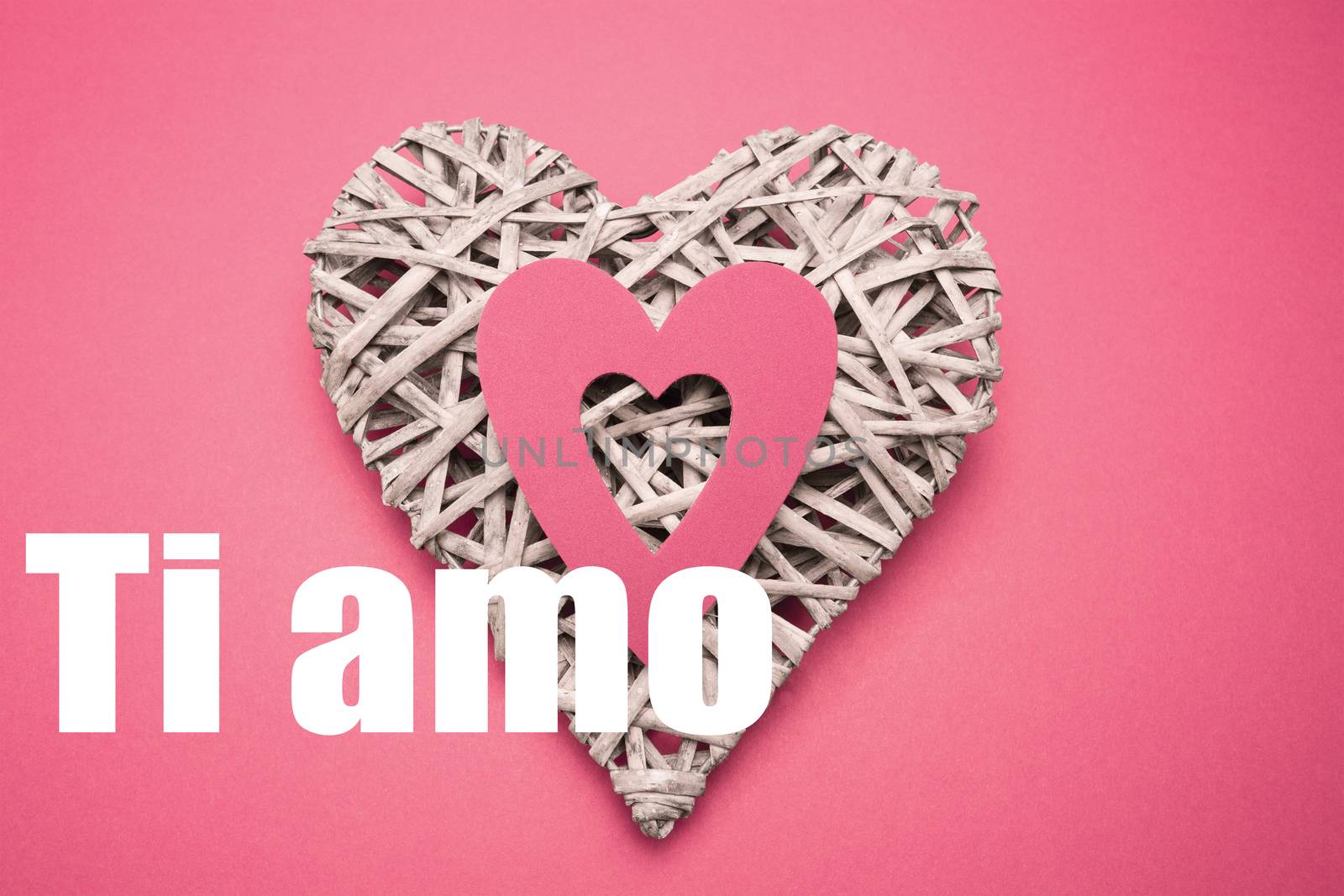 Wicker heart ornament with paper cut out against ti amo