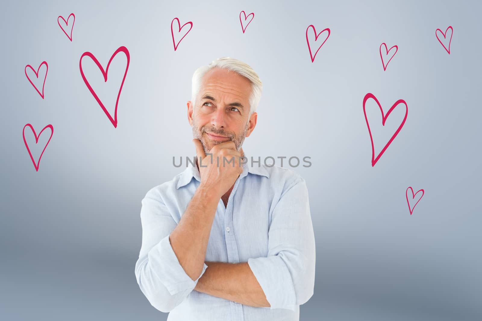 Thoughtful man posing with hand on chin against grey vignette