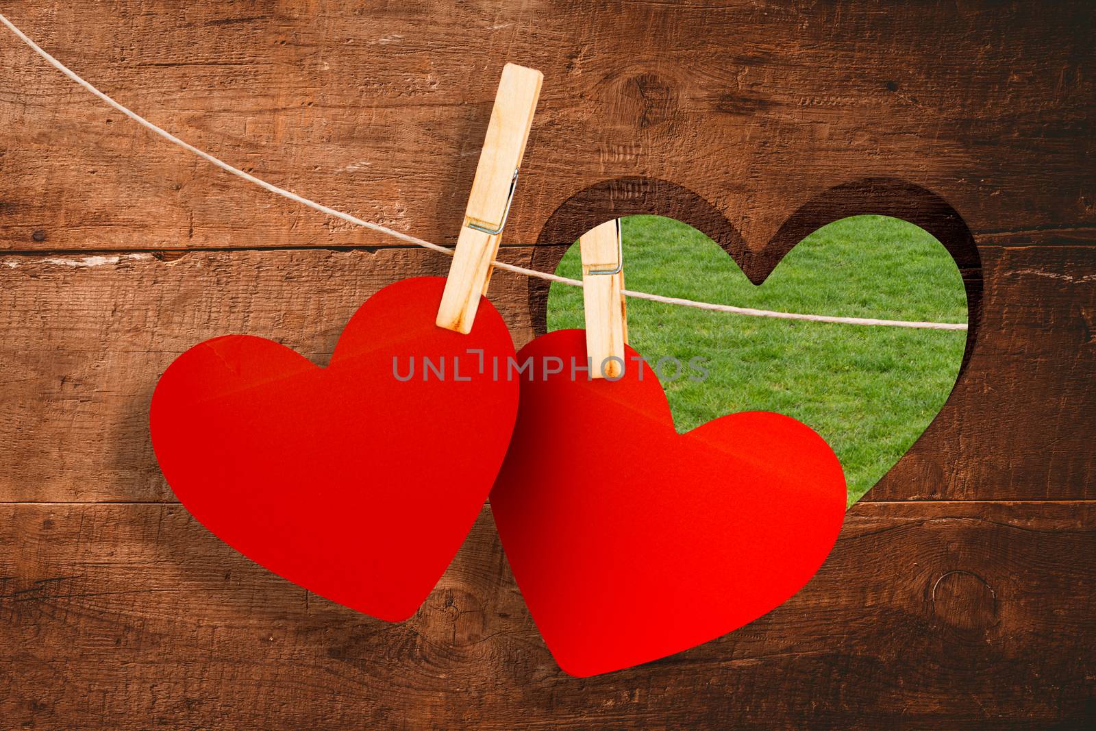 Hearts hanging on line against heart in wood