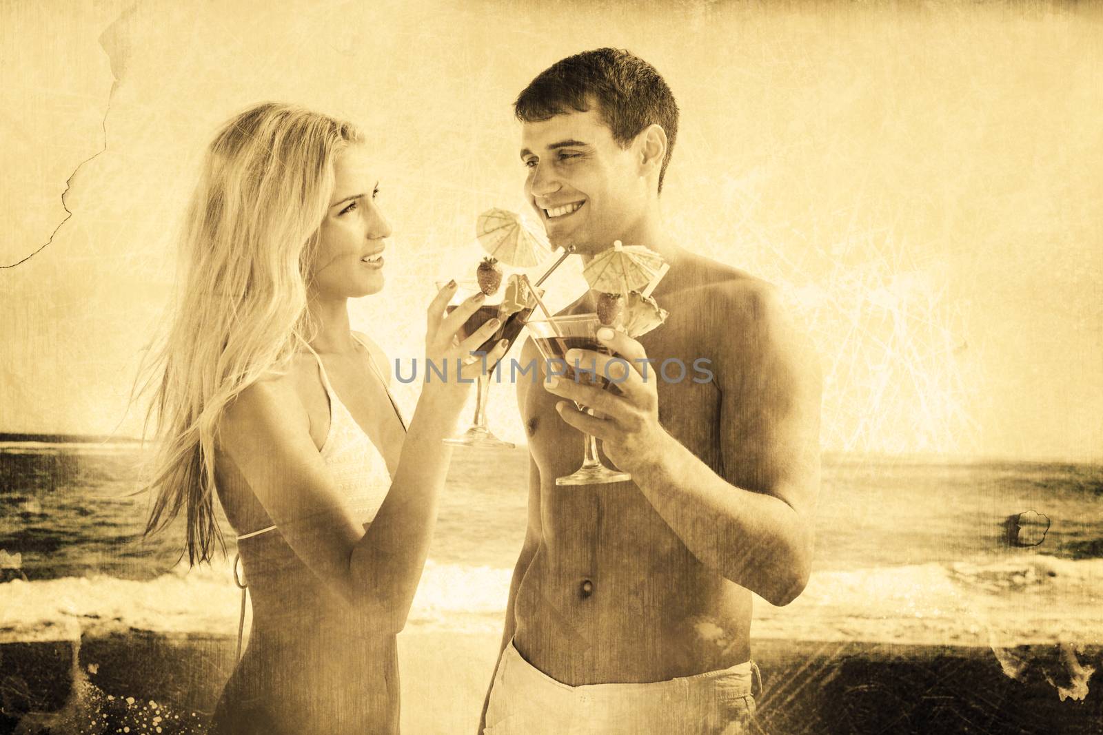 Composite image of happy young couple holding cocktails by Wavebreakmedia