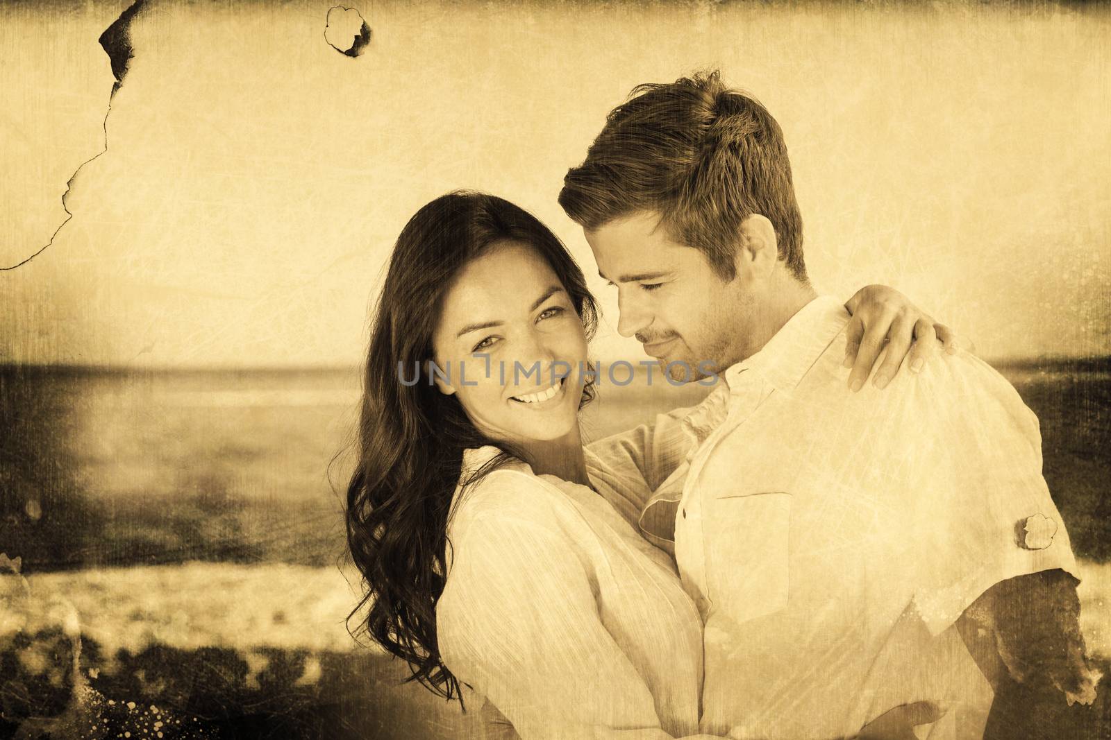 Young couple embracing and posing on the beach  against grey background