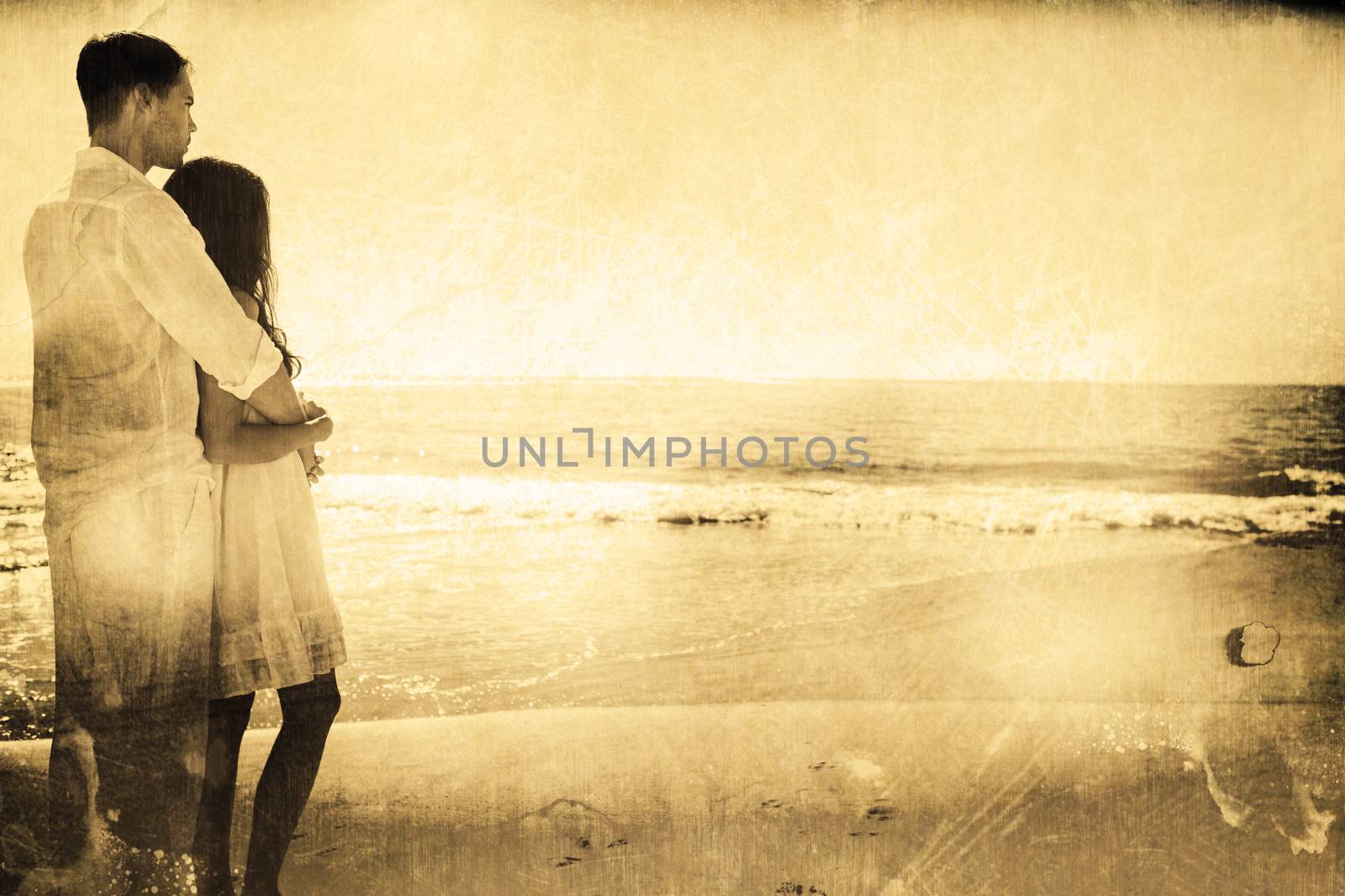 Attractive couple looking out at sea against grey background