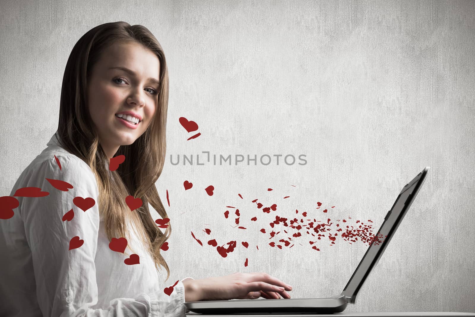 Businesswoman typing on her laptop against white and grey background