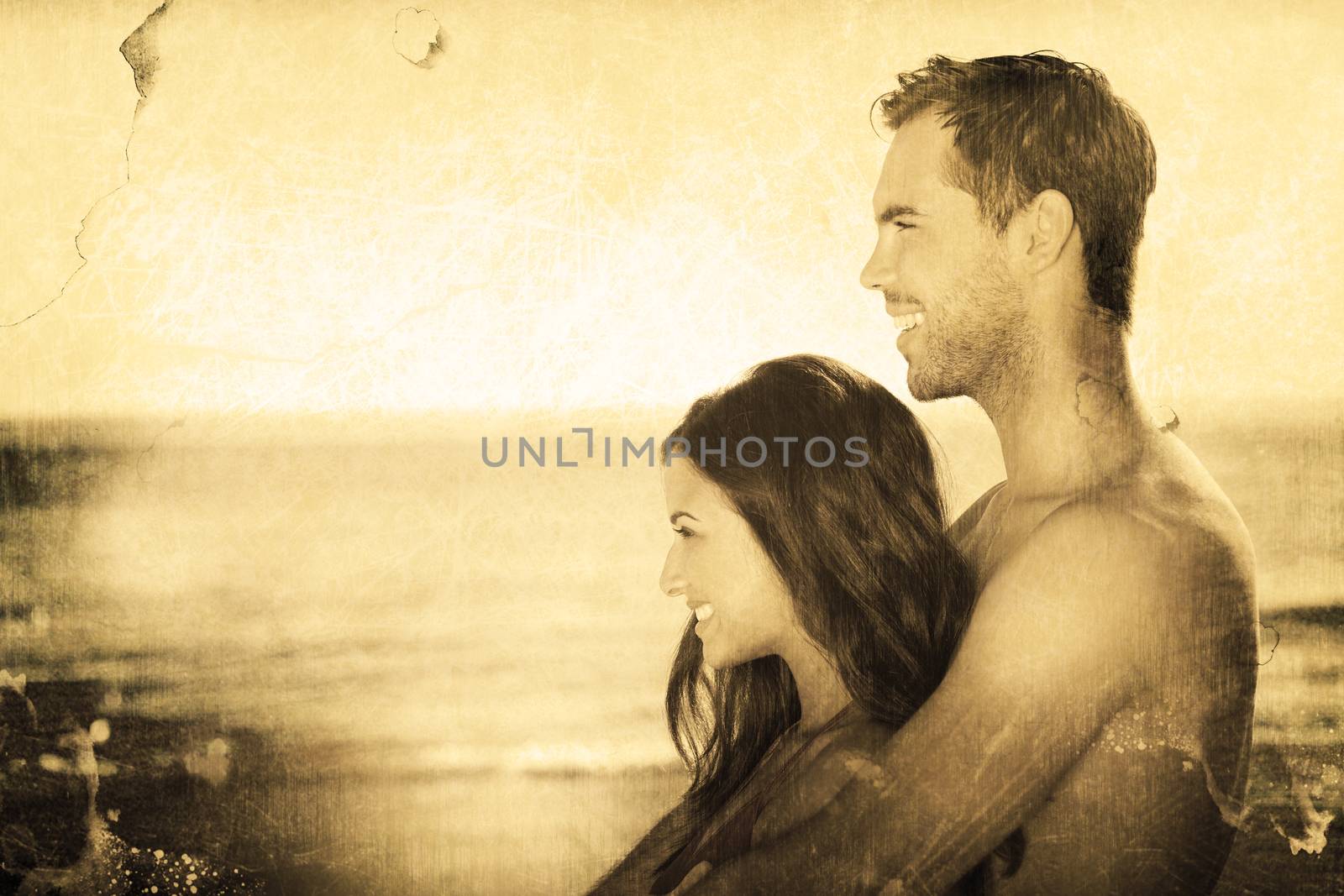 Happy couple in swimsuit hugging while looking at the water against grey background