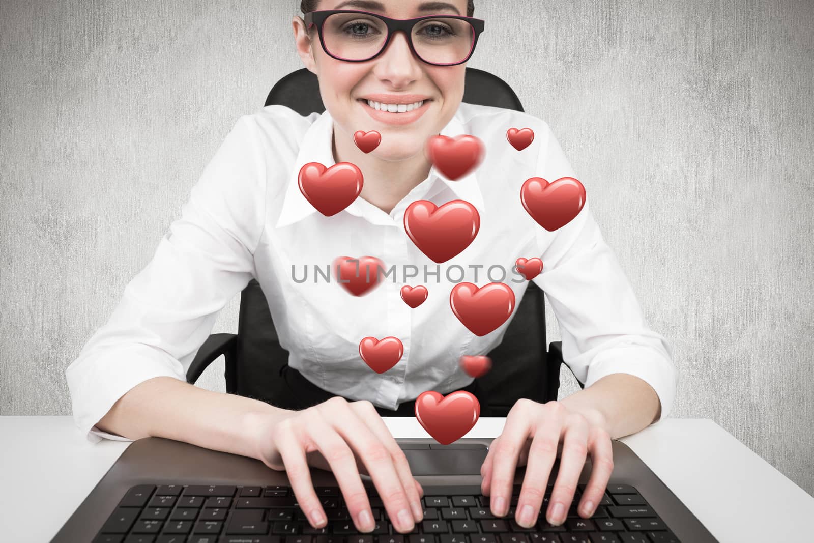 Businesswoman typing on a keyboard against white and grey background