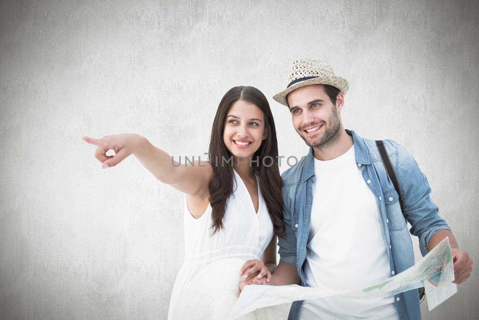 Happy hipster couple looking at map against white background