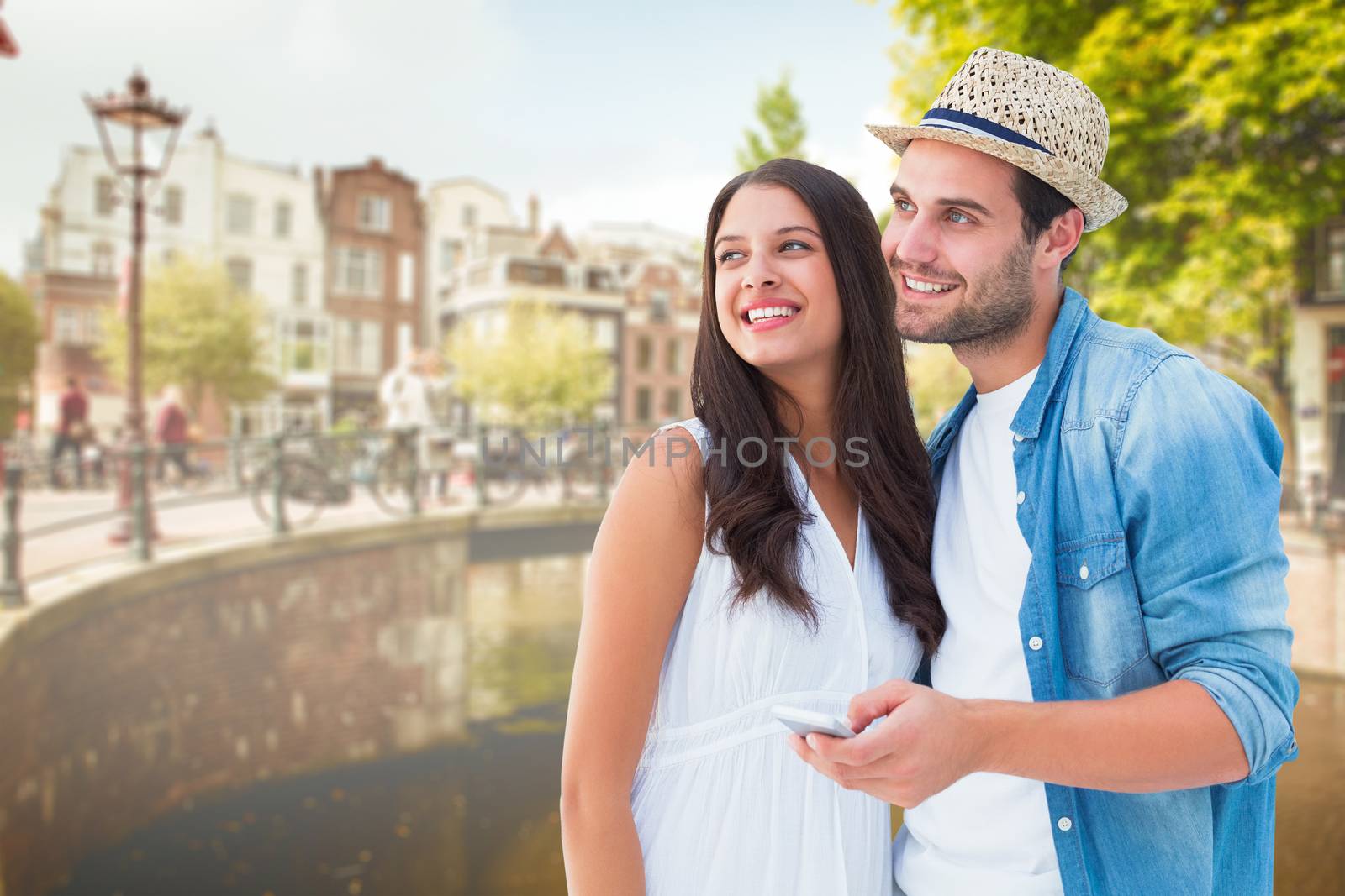 Happy hipster couple smiling together against bridge in amsterdam