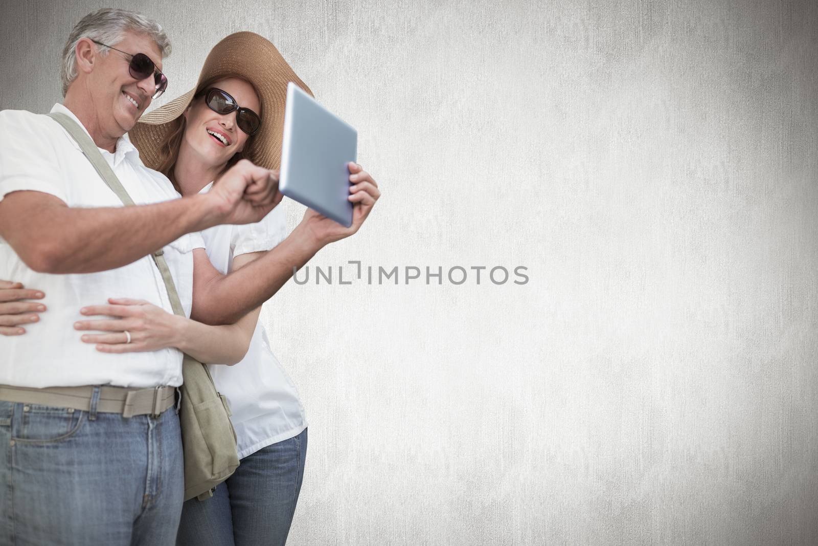 Vacationing couple taking photo against white background