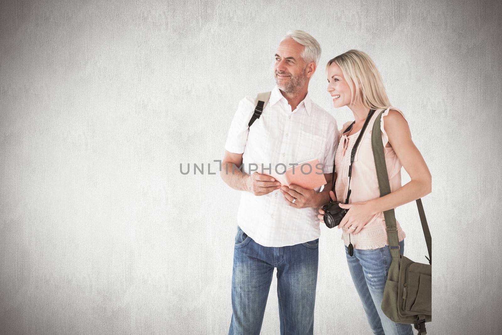 Happy tourist couple using the guidebook against white background