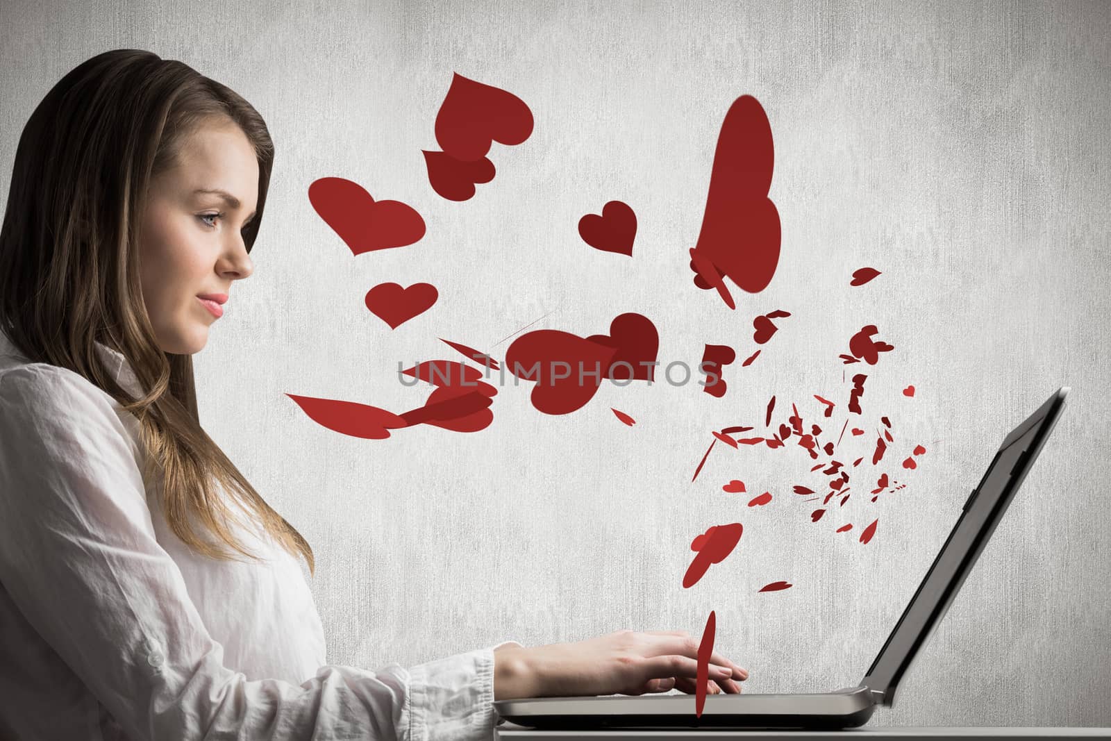 Businesswoman typing on her laptop against white and grey background