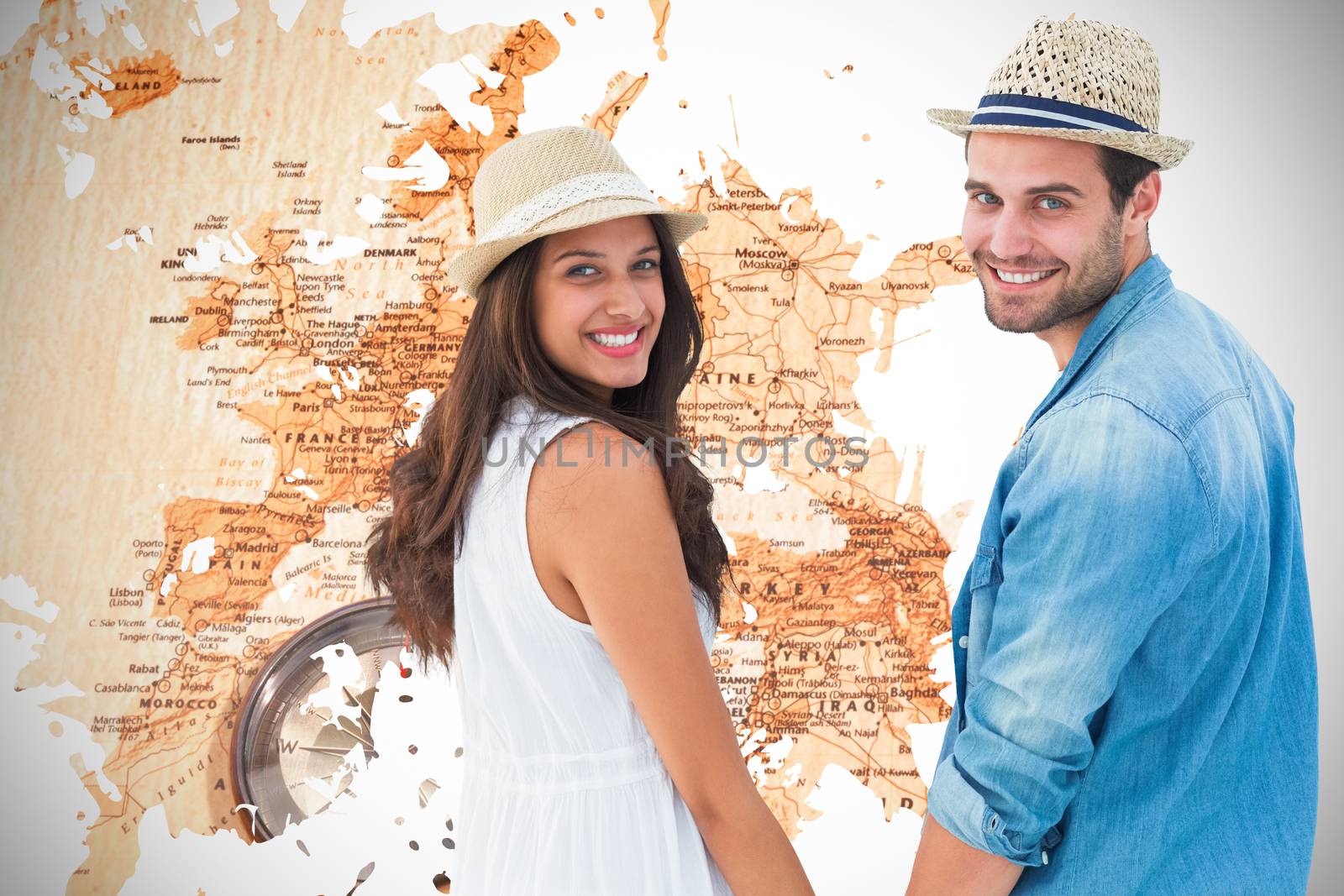 Happy hipster couple holding hands and smiling at camera against world map with compass showing southern asia