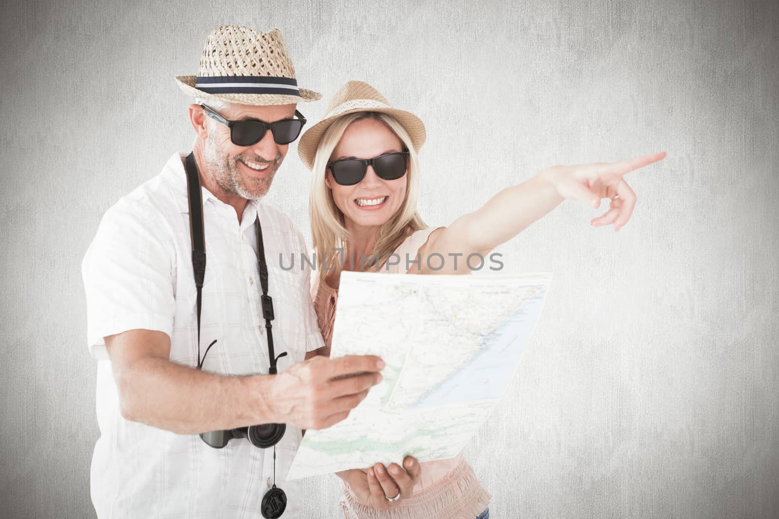 Composite image of happy tourist couple using map and pointing by Wavebreakmedia