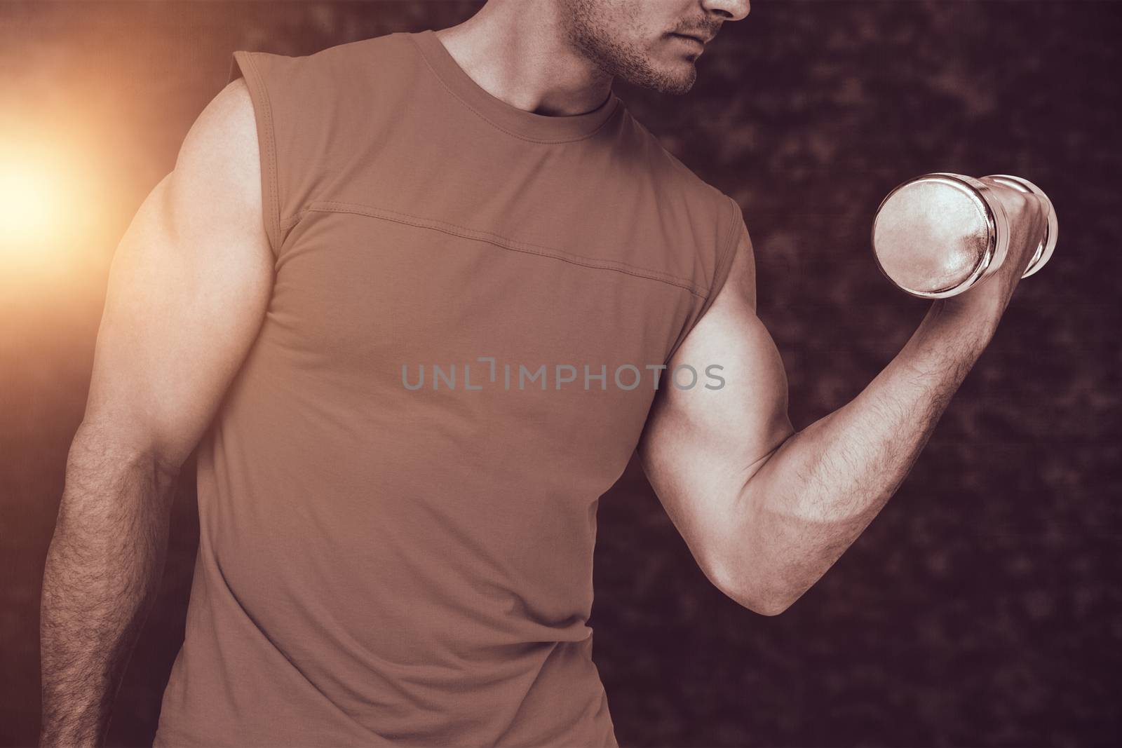 Close-up mid section of fit man exercising with dumbbell against dark grey texture