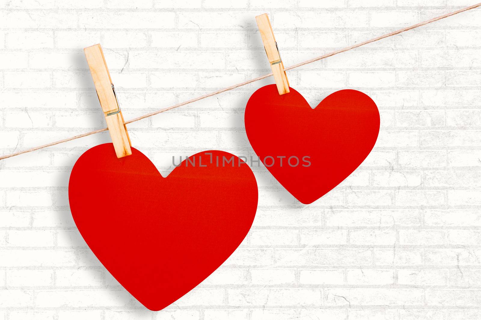 Hearts hanging on a line against white wall