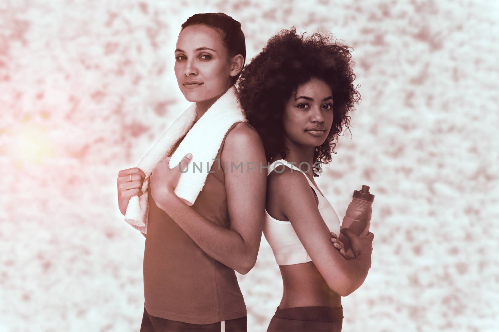 Composite image of fit women standing with waterbottle and towel by Wavebreakmedia