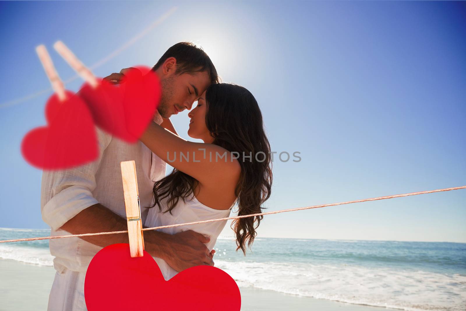 Romantic couple embracing  against hearts hanging on a line
