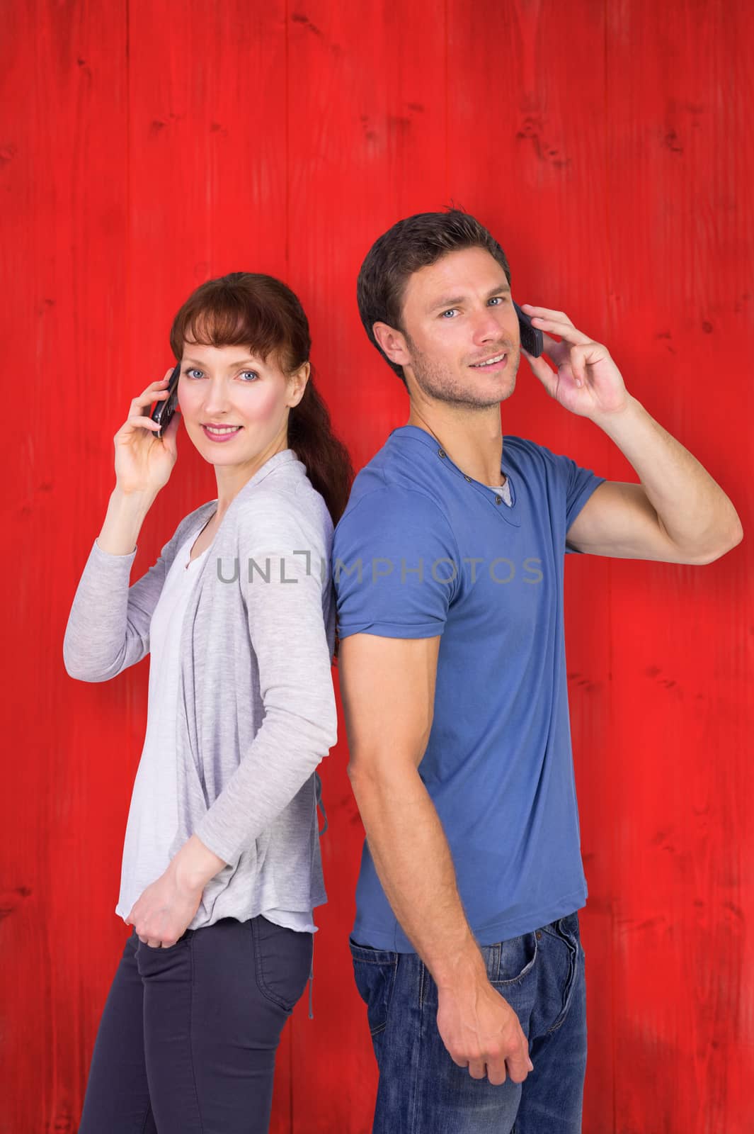 Composite image of couple both making phone calls by Wavebreakmedia