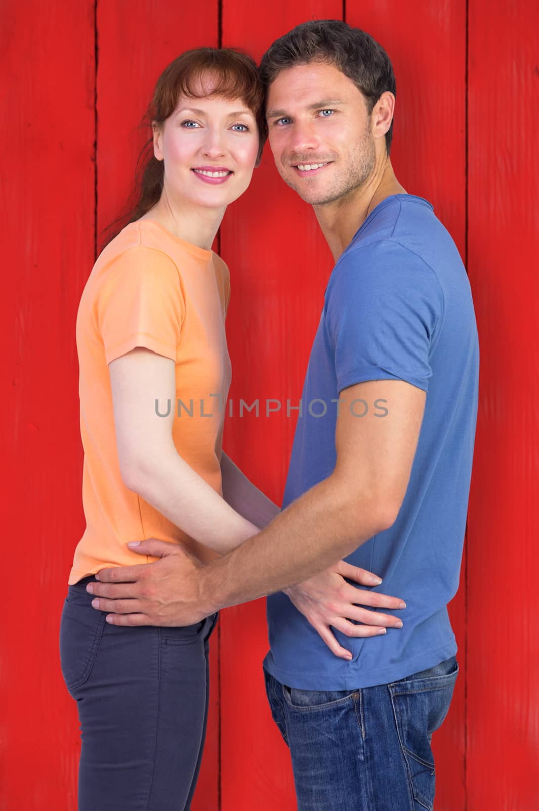 Couple looking at the camera against red wooden planks