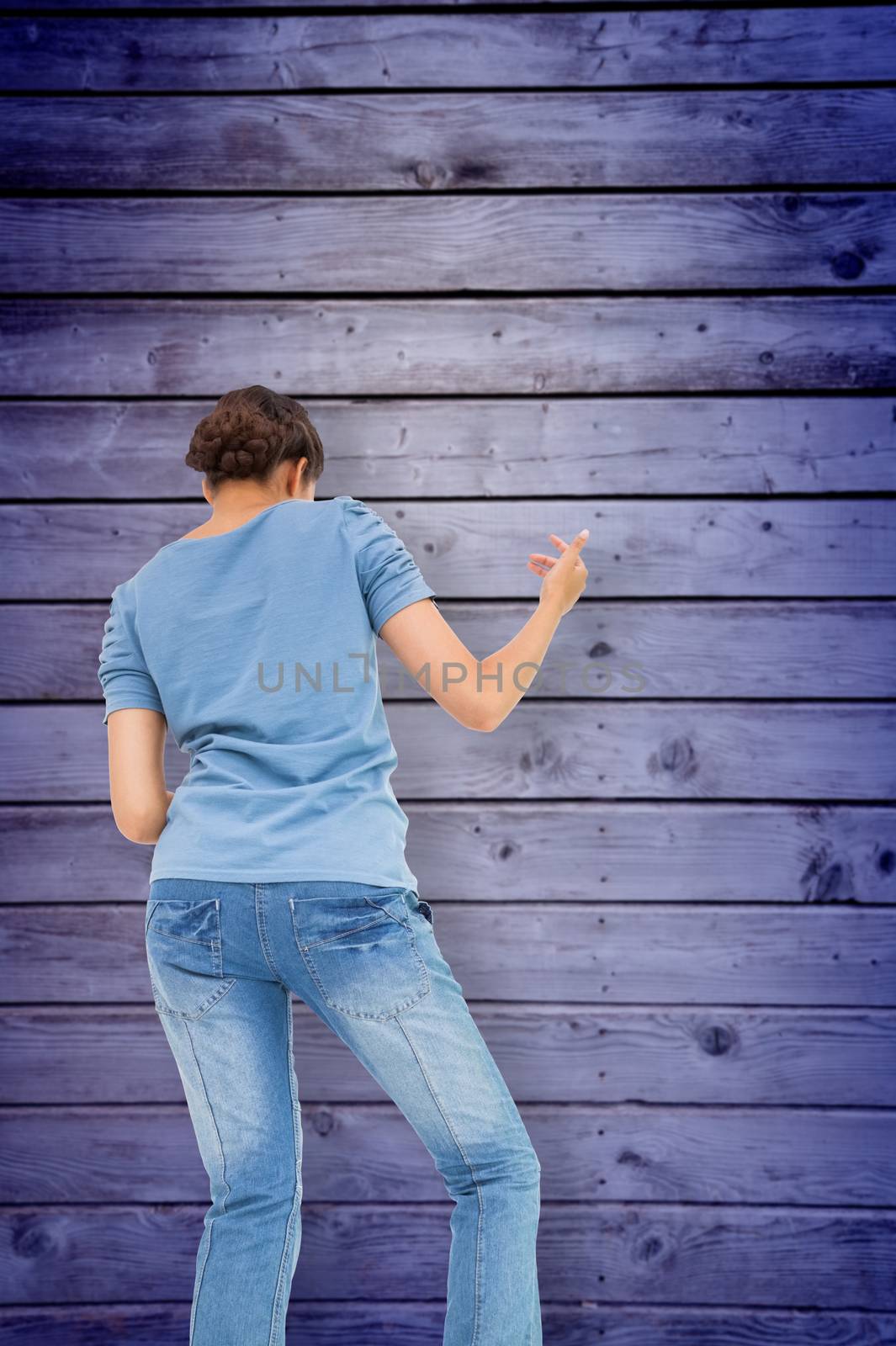 Pretty brunette playing air guitar against wooden planks background
