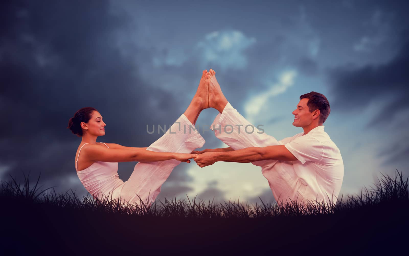 Peaceful couple sitting in boat position together against blue sky over grass